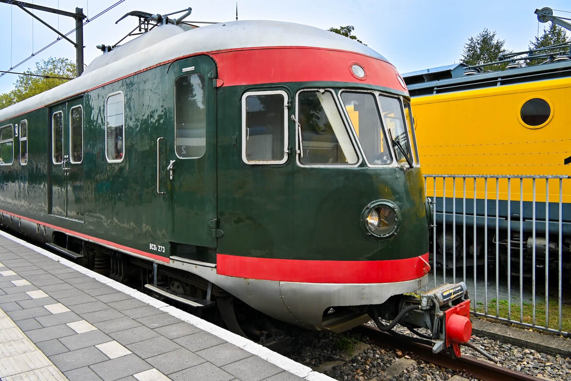 De historische trein Mat '46 staat op Perron 3 van het Spoorwegmuseum Utrecht. De trein is iconisch, met een donkergroene kleur met felrode biezen.